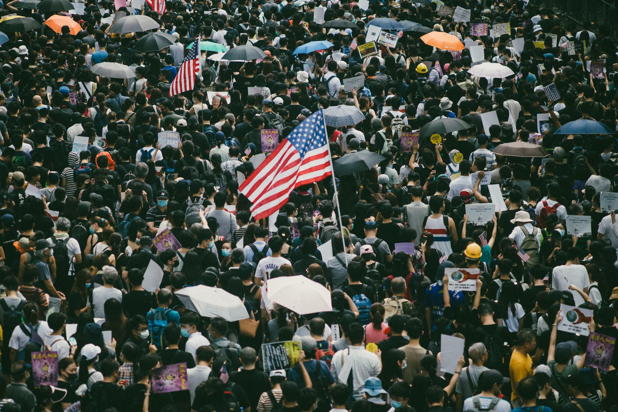 Crowd of people marching with signs and American flags